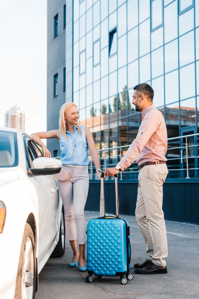 husband and wife with baggage waiting for theyr car rental in albania airport