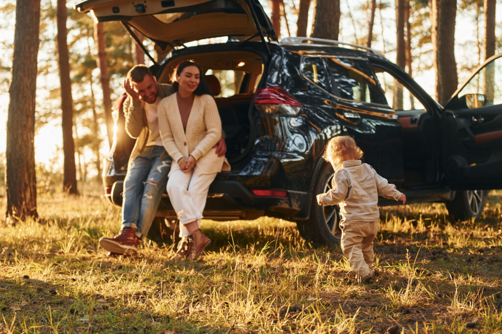 Joy and happiness. Family of father, mother and little daughter is in the forestenjoying a car rental in albania
