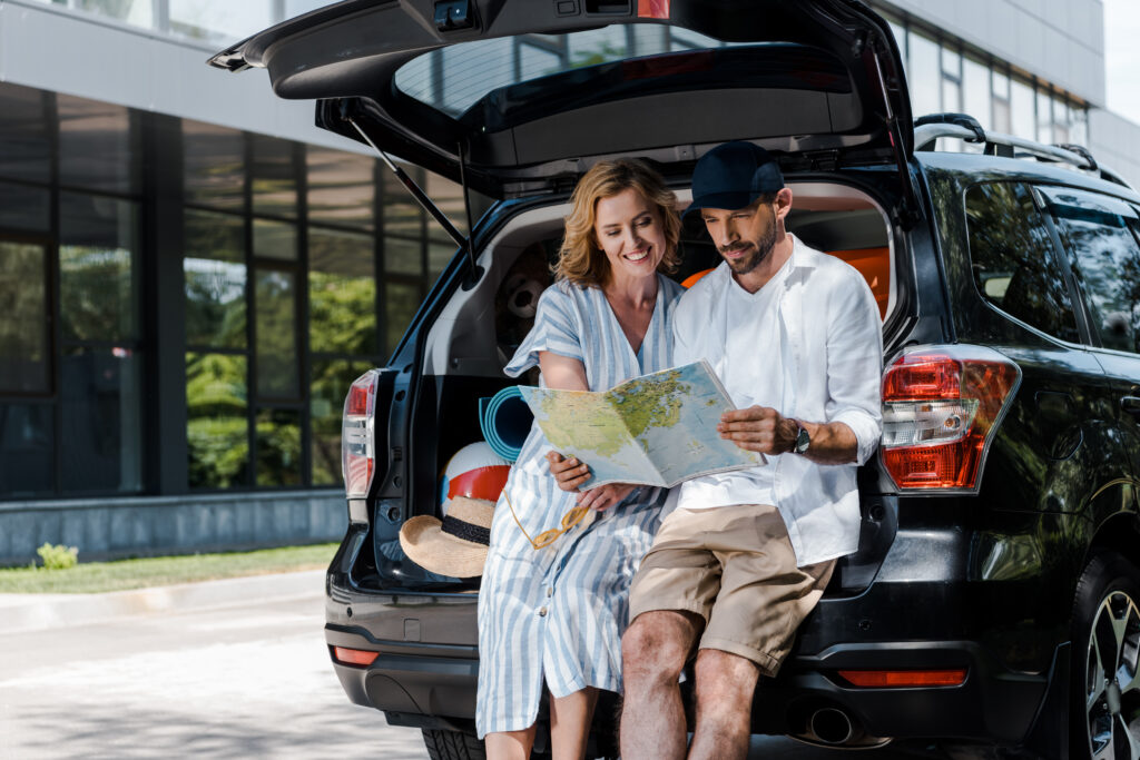 happy couple  holding map chechking for new destinations to visit with theyr car rental in albania